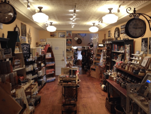 A cozy shop interior filled with various products, shelves, and decorative items, illuminated by overhead lights.