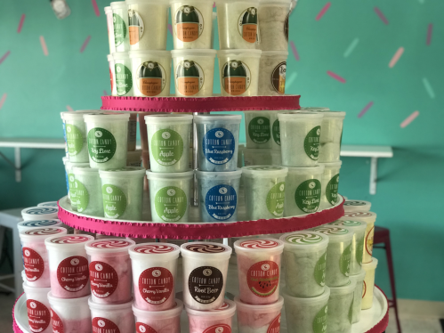 A colorful display of ice cream cups stacked in a tiered arrangement, featuring various flavors and vibrant labels.