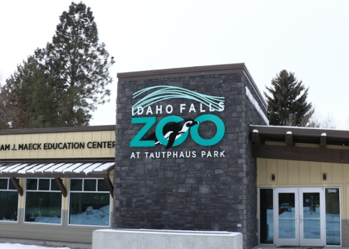 Sign for Idaho Falls Zoo at Tautphaus Park, featuring a modern design and snowy surroundings.