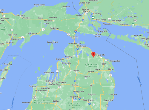 Map showing northern Michigan, highlighting Rogers City with a red marker. Surrounding areas include lakes and forests.