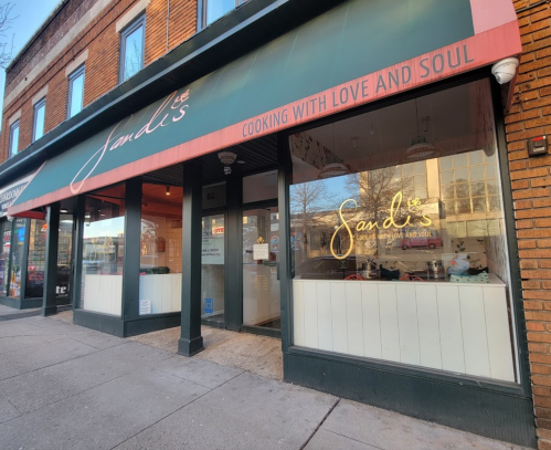 Exterior of Sandis restaurant, featuring a red awning with the name and slogan "Cooking with Love and Soul."