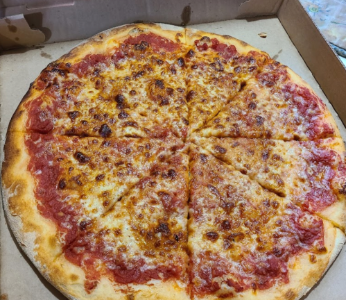 A large cheese pizza with a golden crust, sliced into 12 pieces, in a pizza box.