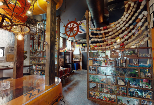 A cozy, nautical-themed interior with fishing nets, buoys, and display cases filled with marine memorabilia.