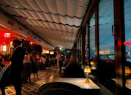 A stylish restaurant interior with dim lighting, elegant decor, and patrons enjoying their meals in a cozy atmosphere.