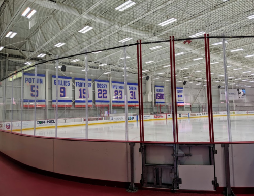 Interior of an ice rink featuring banners with player numbers and names hanging from the ceiling.