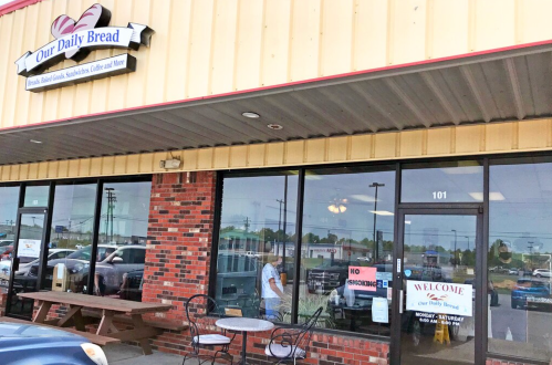 Exterior of "Our Daily Bread" bakery with a sign welcoming customers and a "No Smoking" notice on the door.