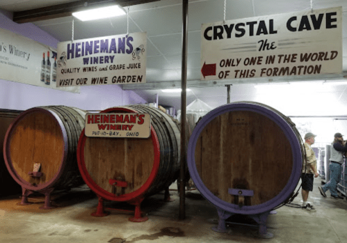 Interior of Heineman's Winery featuring large wine barrels and signs for the winery and Crystal Cave attraction.