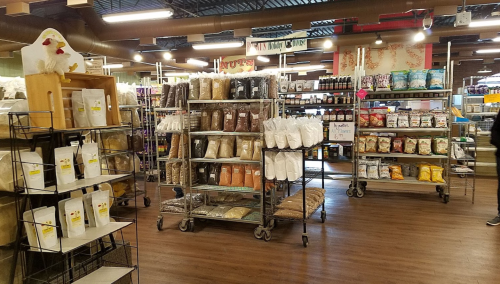 A spacious store aisle filled with shelves of various packaged food items and bulk ingredients.