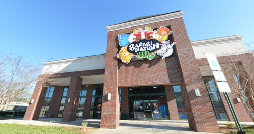 Exterior of Safari Nation building with colorful animal-themed signage and clear blue sky.