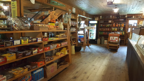 A cozy, rustic store interior with wooden shelves filled with snacks and candies, and a warm, inviting atmosphere.