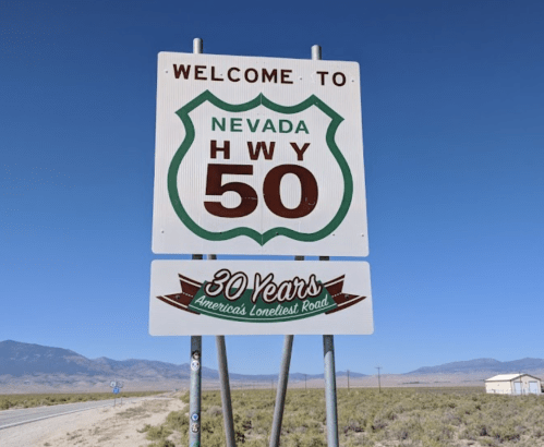 Sign welcoming travelers to Nevada Highway 50, labeled "America's Loneliest Road," with a 30-year anniversary note.