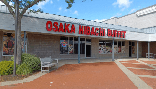 Exterior of Osaka Hibachi Buffet with large red signage and windows displaying food images. Clear blue sky above.
