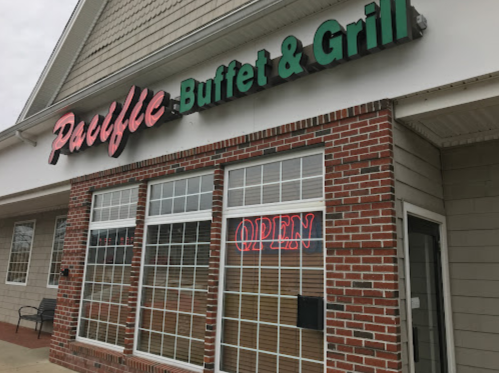 Exterior of Paulie's Buffet & Grill, featuring a brick facade and an illuminated "OPEN" sign in the window.