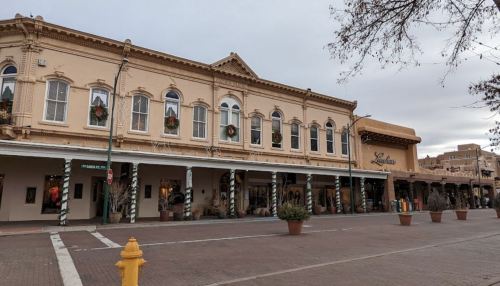 Historic building with decorative windows and holiday wreaths, featuring shops and a festive atmosphere.