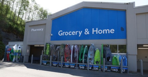 The Grocery and Home entrance of a Walmart Supercenter in Ketchikan, Alaska, featuring a display of outdoor kayaks and sporting goods for sale