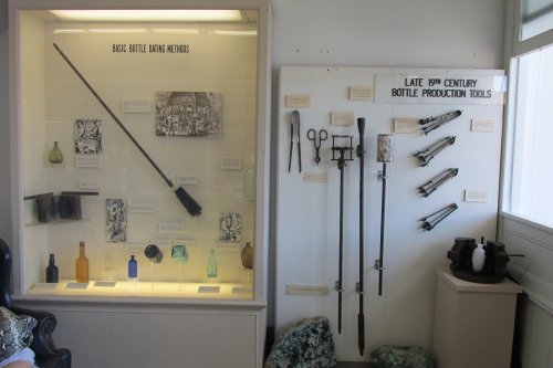 Display of historical bottle production tools and battle gaming methods, featuring various artifacts and descriptions.