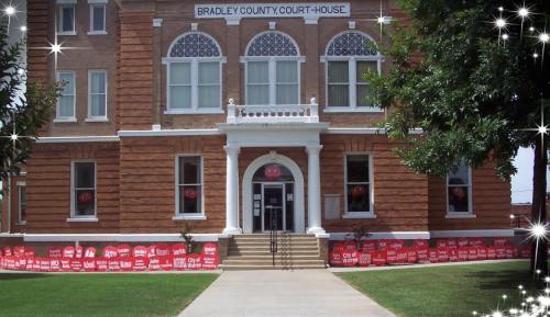 Historic Bradley County Courthouse with decorative windows and a welcoming entrance, surrounded by greenery.