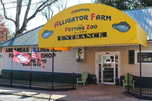 Entrance of Arkansas Alligator Farm and Petting Zoo, featuring a yellow awning and flags outside.