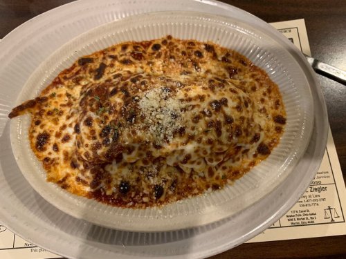 A baked pasta dish topped with melted cheese and marinara sauce, served in a white dish.