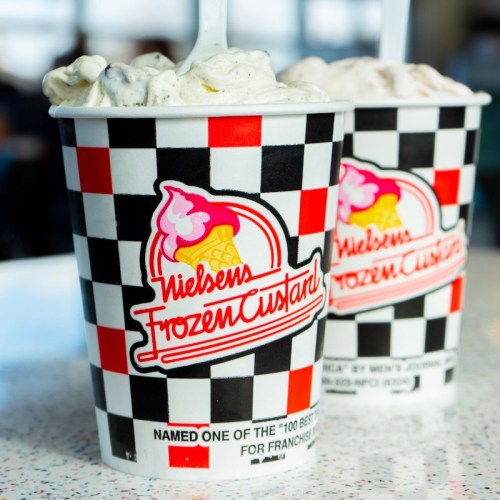 Two cups of frozen custard with a checkered design, featuring the Nielsen's Frozen Custard logo.