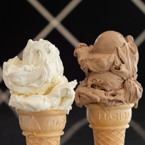 Two ice cream cones: one with creamy vanilla and the other with rich chocolate, set against a dark background.