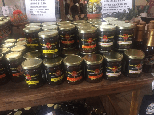 A display of jars labeled "Dateland Dates" featuring various flavors like date butter and raspberry.