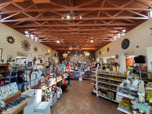 A spacious store interior filled with various products, decorative items, and a wooden ceiling with beams.