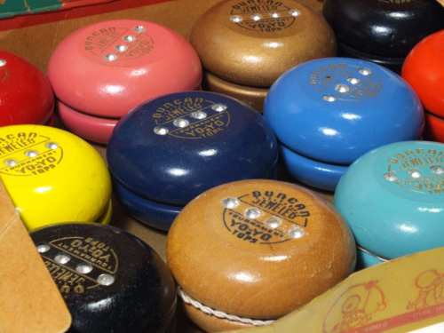 A collection of colorful yo-yos in various shades, featuring logos and designs on their surfaces.