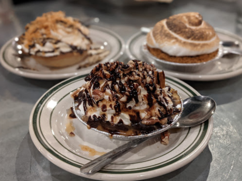 Three delicious desserts on plates: a chocolate sundae with nuts, a toasted meringue pie, and a coconut cream pie.
