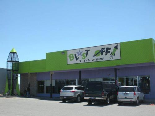 A colorful building with a rocket-shaped structure, featuring a sign that reads "Blast Off! 5-4-3-2-Fun!"
