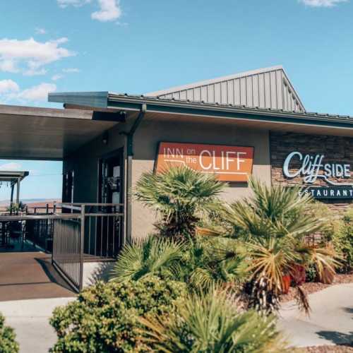 A restaurant building with a sign reading "Cliffside Restaurant" and "Inn on the Cliff," surrounded by greenery.