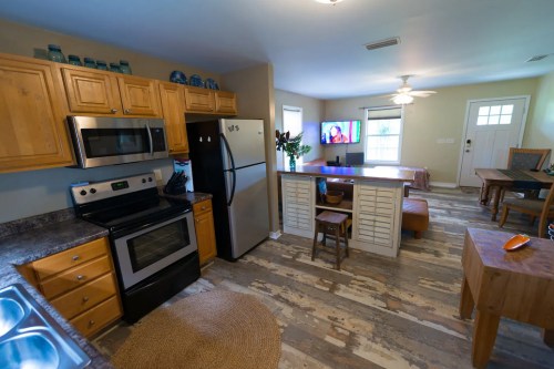 Cozy kitchen with wooden cabinets, stainless steel appliances, and an open layout featuring a dining area and living space.