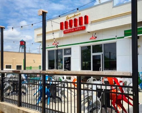 Exterior of Havana Tropical Grill with colorful chairs on the patio and a clear blue sky in the background.