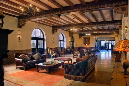 Elegant lobby with wooden beams, plush seating, and decorative lighting, creating a warm and inviting atmosphere.