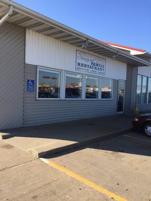 Exterior of Swers Family Restaurant, featuring a sign and large windows, with a clear blue sky above.