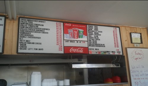 Menu board displaying various food items and prices, including burgers, sandwiches, and sides.