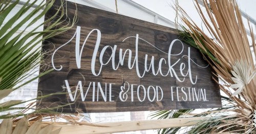 Sign for the Nantucket Wine & Food Festival, featuring a rustic wooden design and decorative palm leaves.