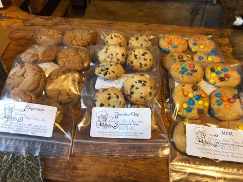 A display of assorted cookies in clear bags, including ginger snap, chocolate chip, and M&M varieties.