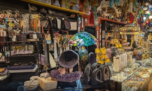 A vibrant shop filled with crystals, gemstones, and decorative items, showcasing colorful displays and unique treasures.