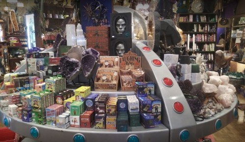 A colorful display of various mystical and spiritual items, including crystals, tarot cards, and decorative boxes.