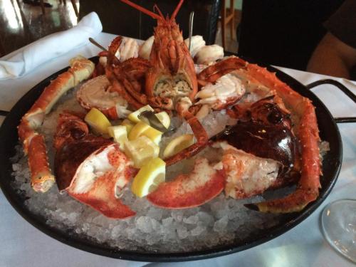 A seafood platter featuring lobster, crab, and shrimp, garnished with lemon slices on a bed of ice.
