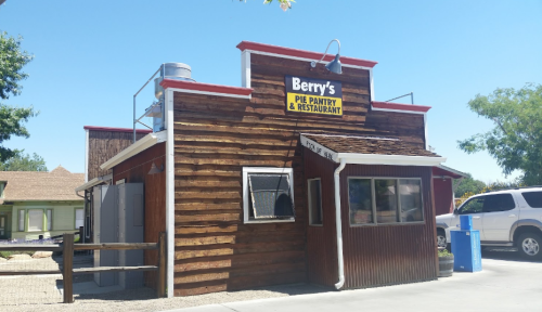 Exterior of Berry's Pie Pantry & Restaurant, featuring a wooden facade and a sign, under a clear blue sky.