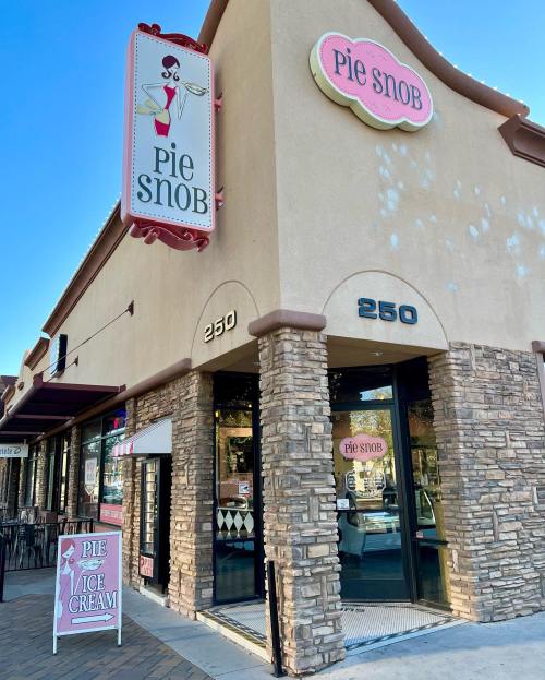 Exterior of Pie Snob shop featuring a sign and a sandwich board advertising pie and ice cream.