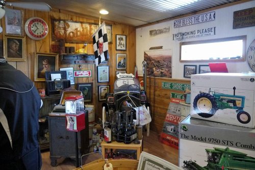 A vintage-themed room filled with memorabilia, including signs, photos, and a classic tractor model.