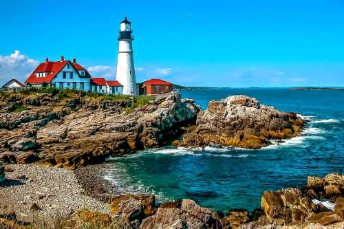 A scenic lighthouse on rocky shores, with a red-roofed house and clear blue skies above the ocean.