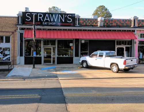 Exterior of Strawn's Eat Shop with a red awning and a white pickup truck parked outside on a sunny day.