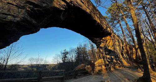 Sandstone rock formation in Kentucky resembling a natural arch at sunset