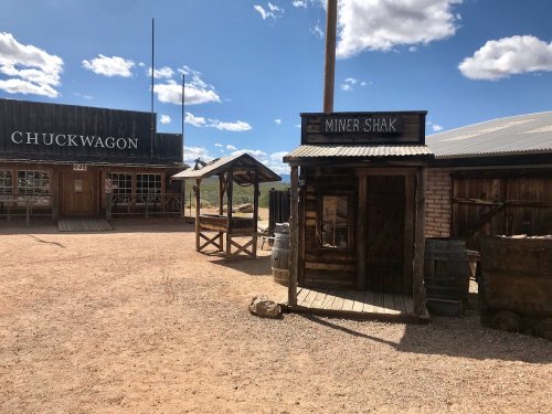 A rustic western town scene featuring a "Miner Shak" and "Chuckwagon" buildings under a blue sky with clouds.