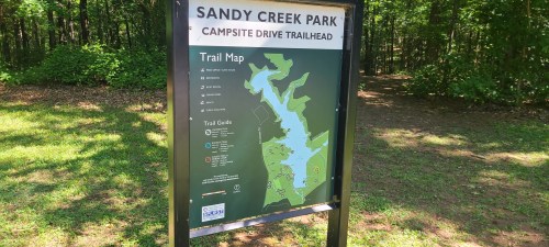 Map of Sandy Creek Park showing trails and campsite locations, surrounded by greenery.