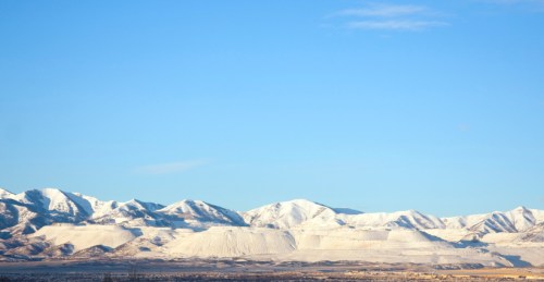 Snow-covered mountains under a clear blue sky, showcasing a serene winter landscape.
